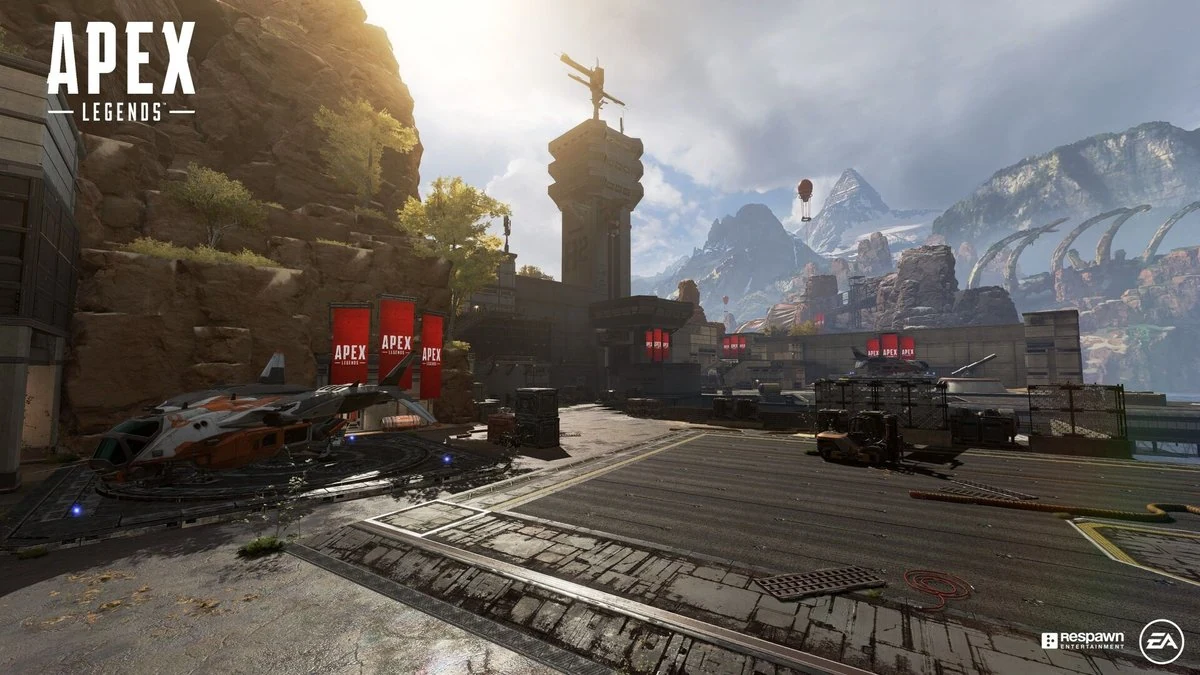 Apex Legends - rocky outpost map with helicopter pad and red banners under a clear sky, showcasing live-service free-to-play hero shooter design