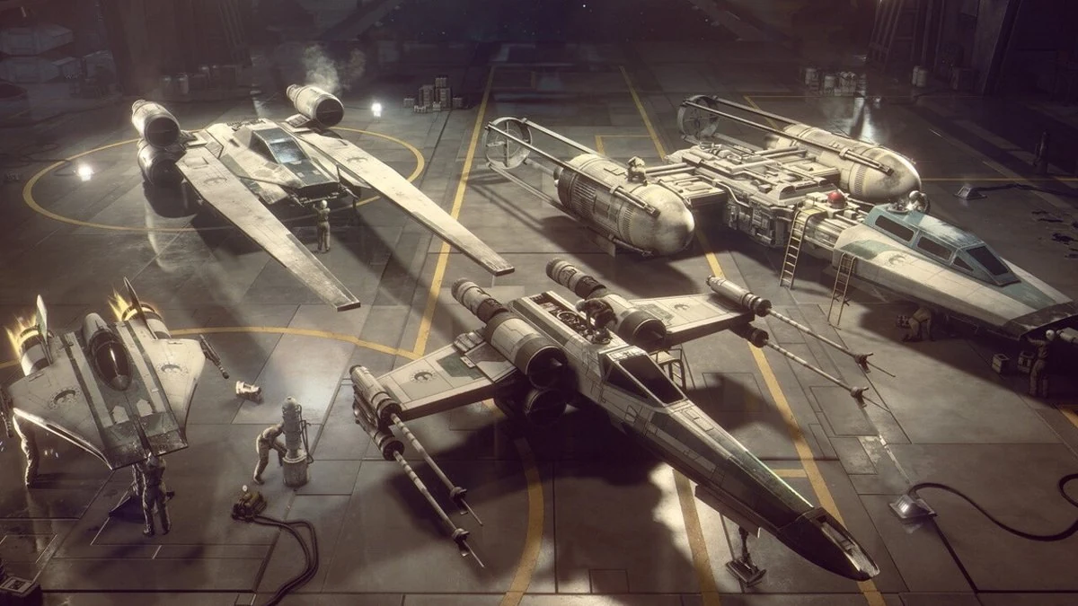 Vehicle concept art of X-wing, Y-wing and A-wing starfighters parked in a Rebel hangar bay with crew members preparing them, from Star Wars: Squadrons